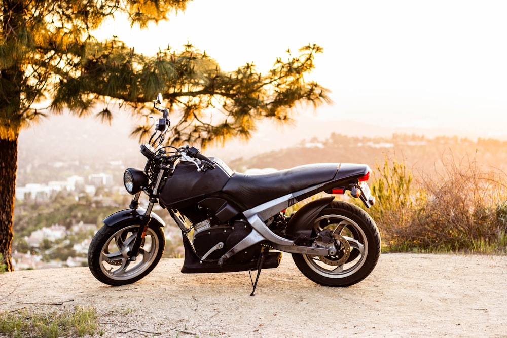 black motorcycle parked on gray concrete road during daytime