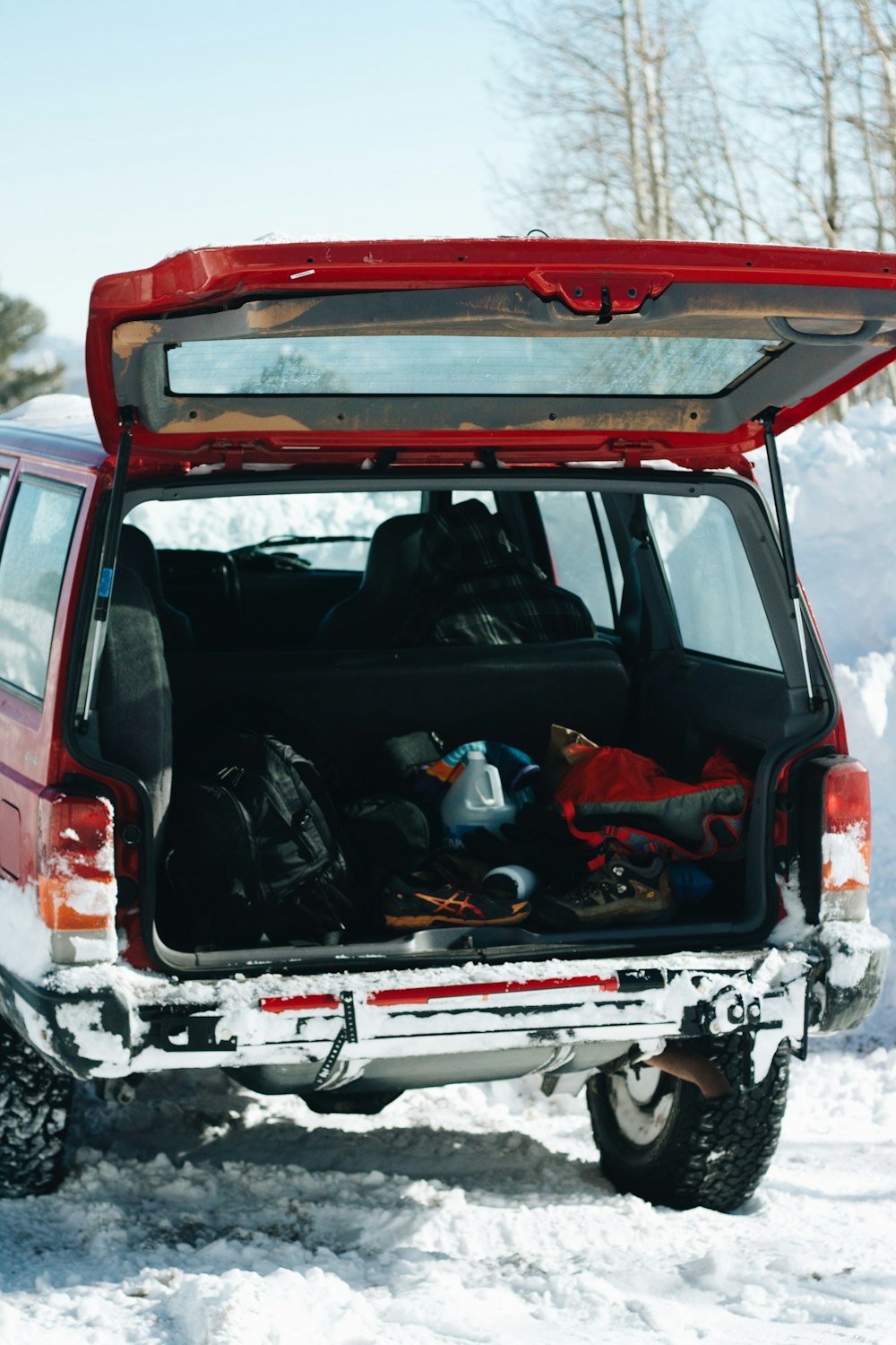 red and black car on snow covered ground during daytime