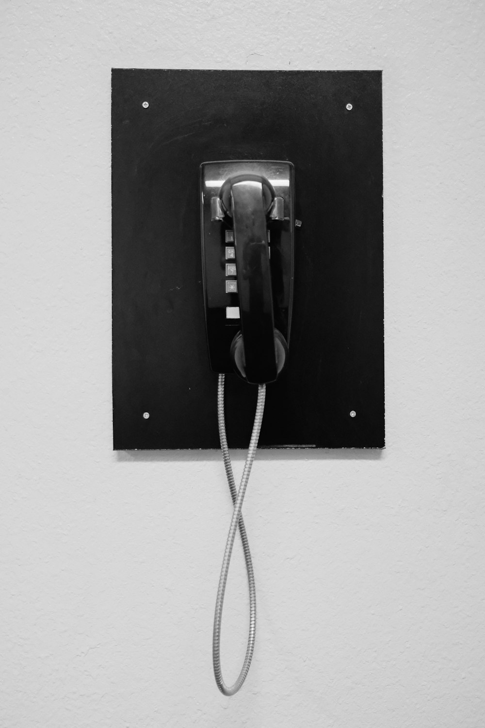 teléfono negro sobre pared blanca