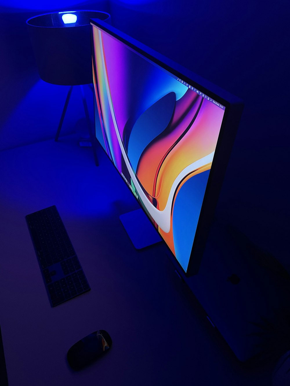 Téléviseur à écran plat noir allumé affichant du bleu et du rouge