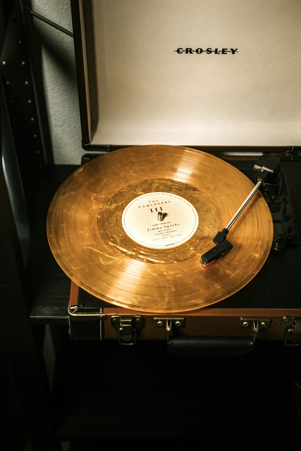 brown vinyl record on black wooden shelf