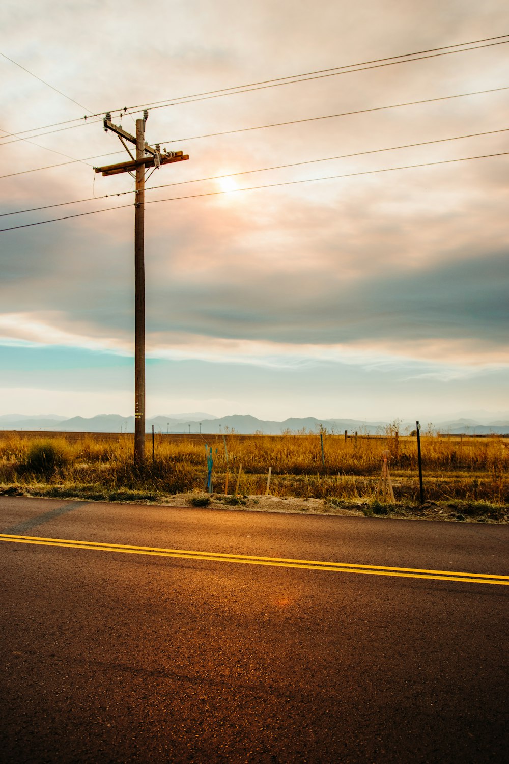 gray concrete road near brown grass field during daytime