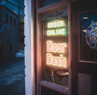 brown wooden door with red and yellow neon sign