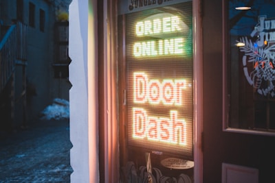 brown wooden door with red and yellow neon sign