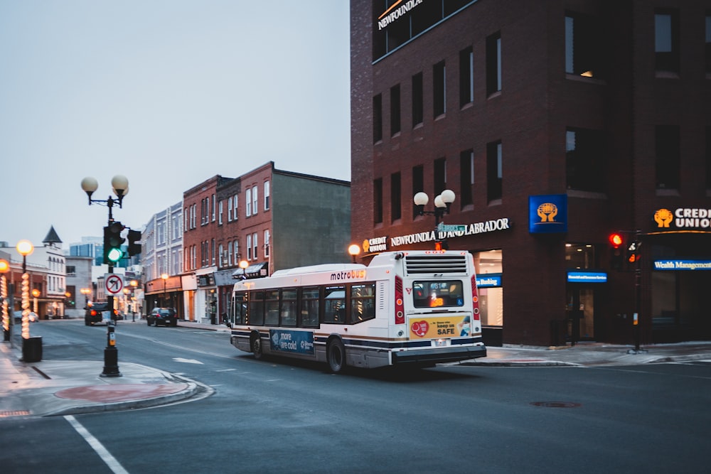 white and red bus on road near building during daytime