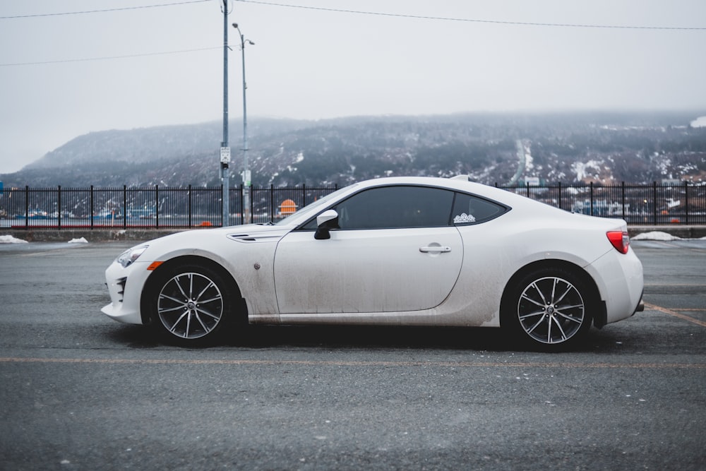 white porsche 911 parked on gray asphalt road during daytime