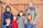 A happy family standing next to a newly built wooden fence.