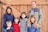 A happy family standing next to a newly built wooden fence.
