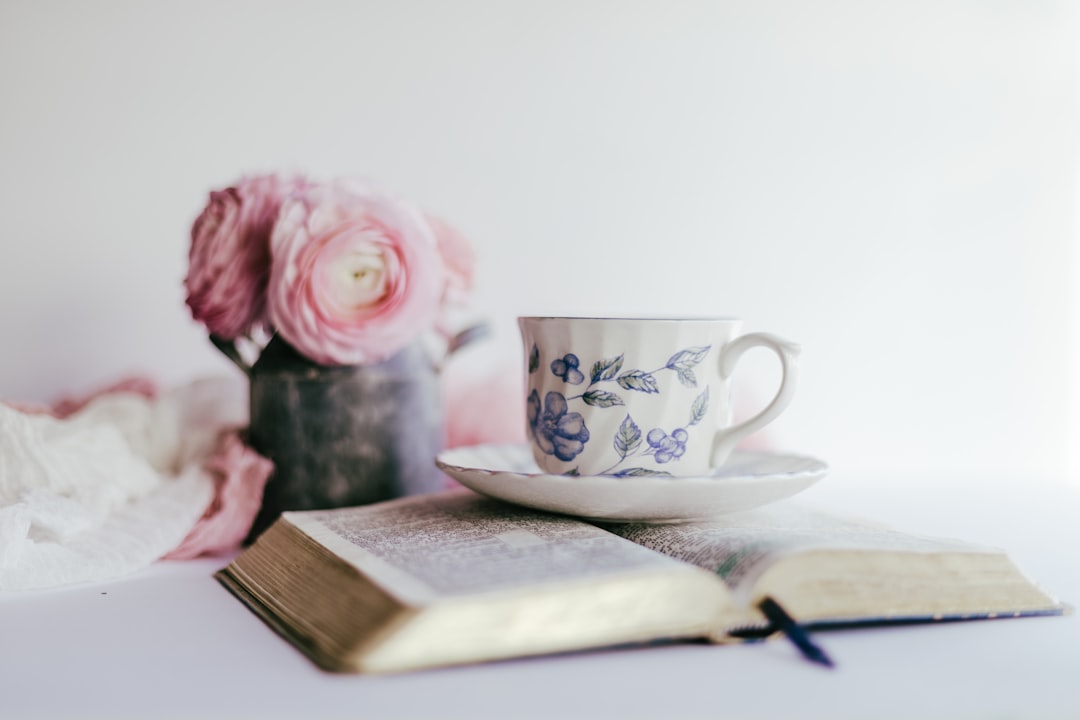 white and pink floral ceramic teacup on white ceramic saucer