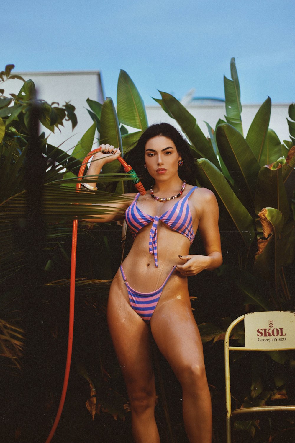 woman in blue and white bikini standing beside green plant