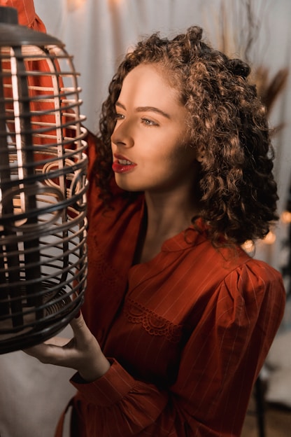 woman in red dress holding black metal basket