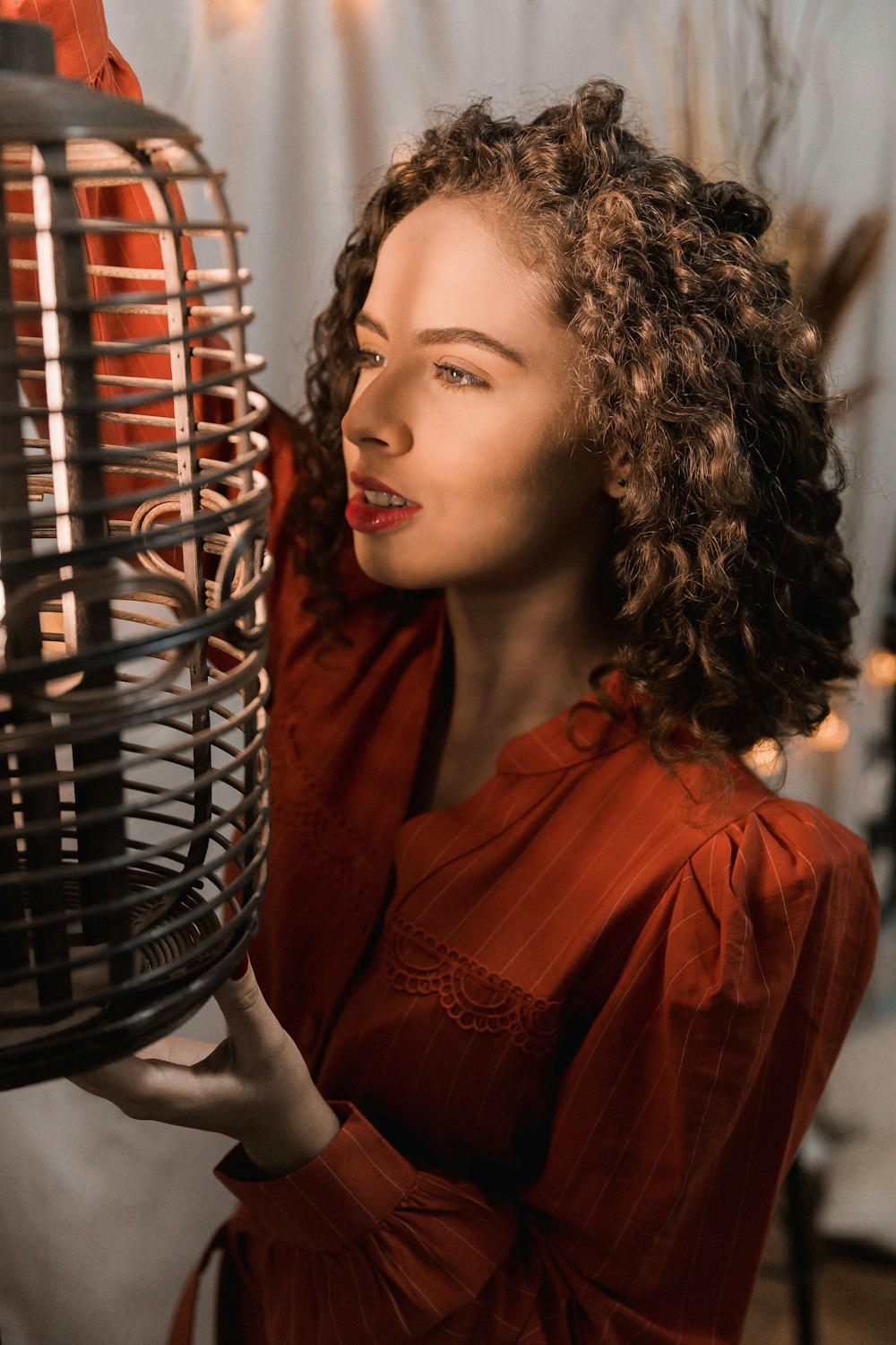 woman in red dress holding black metal basket