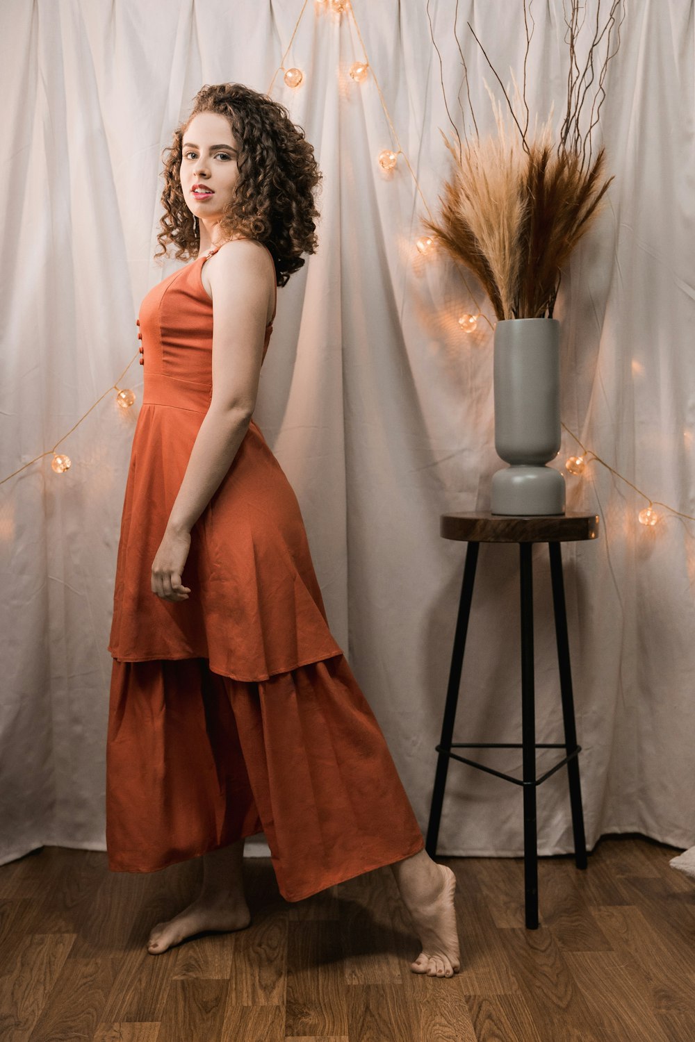 woman in pink dress standing beside black metal stand