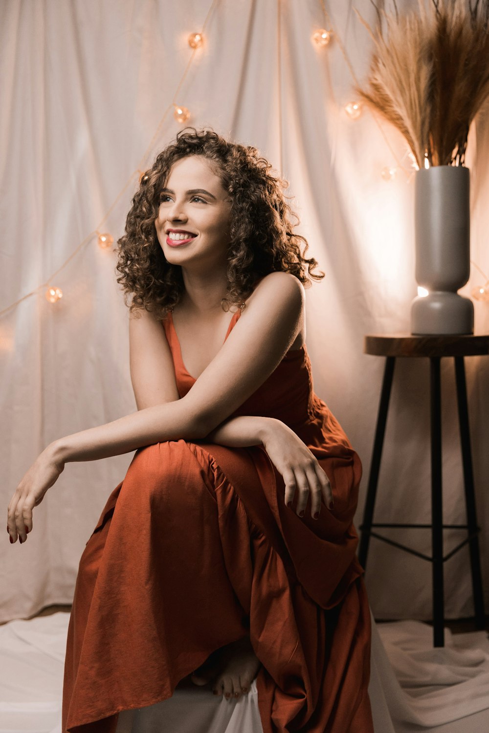 woman in red sleeveless dress sitting on brown wooden chair