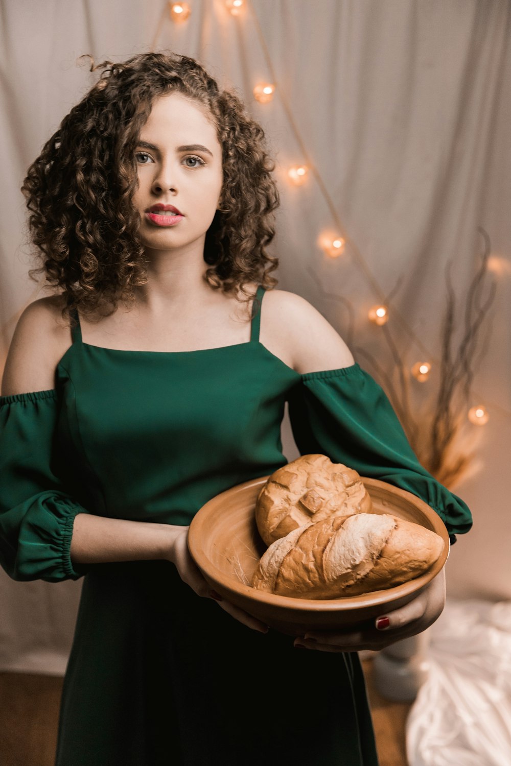 woman in green spaghetti strap top holding brown bread