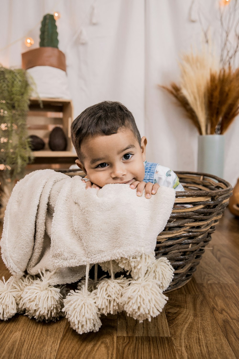 Niño en toalla de baño blanca sentado en canasta tejida