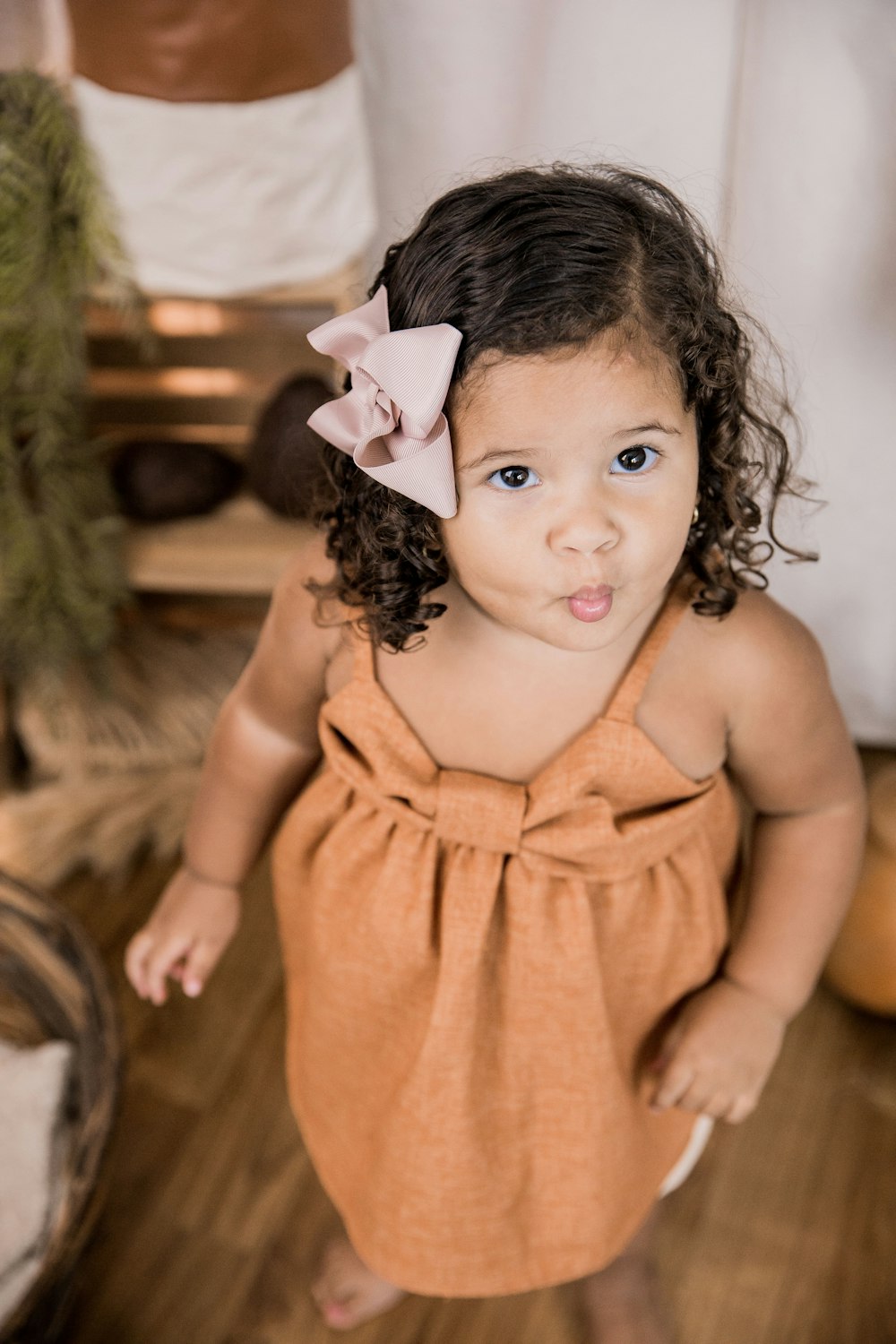 girl in orange sleeveless dress with white and black flower headband