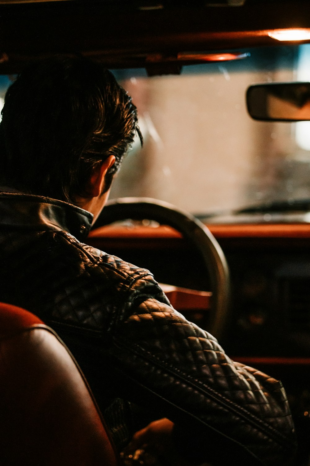 man in black and white plaid dress shirt driving car