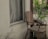 A cozy wooden chair placed next to a small decorative plant on a light background.