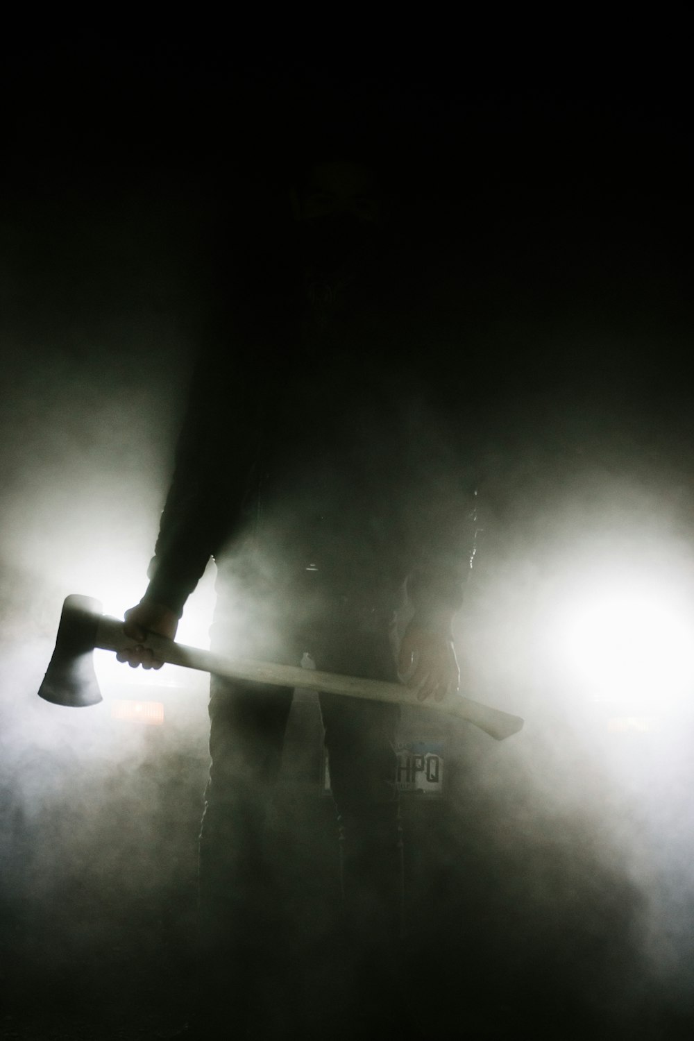 man in black long sleeve shirt holding brown wooden stick