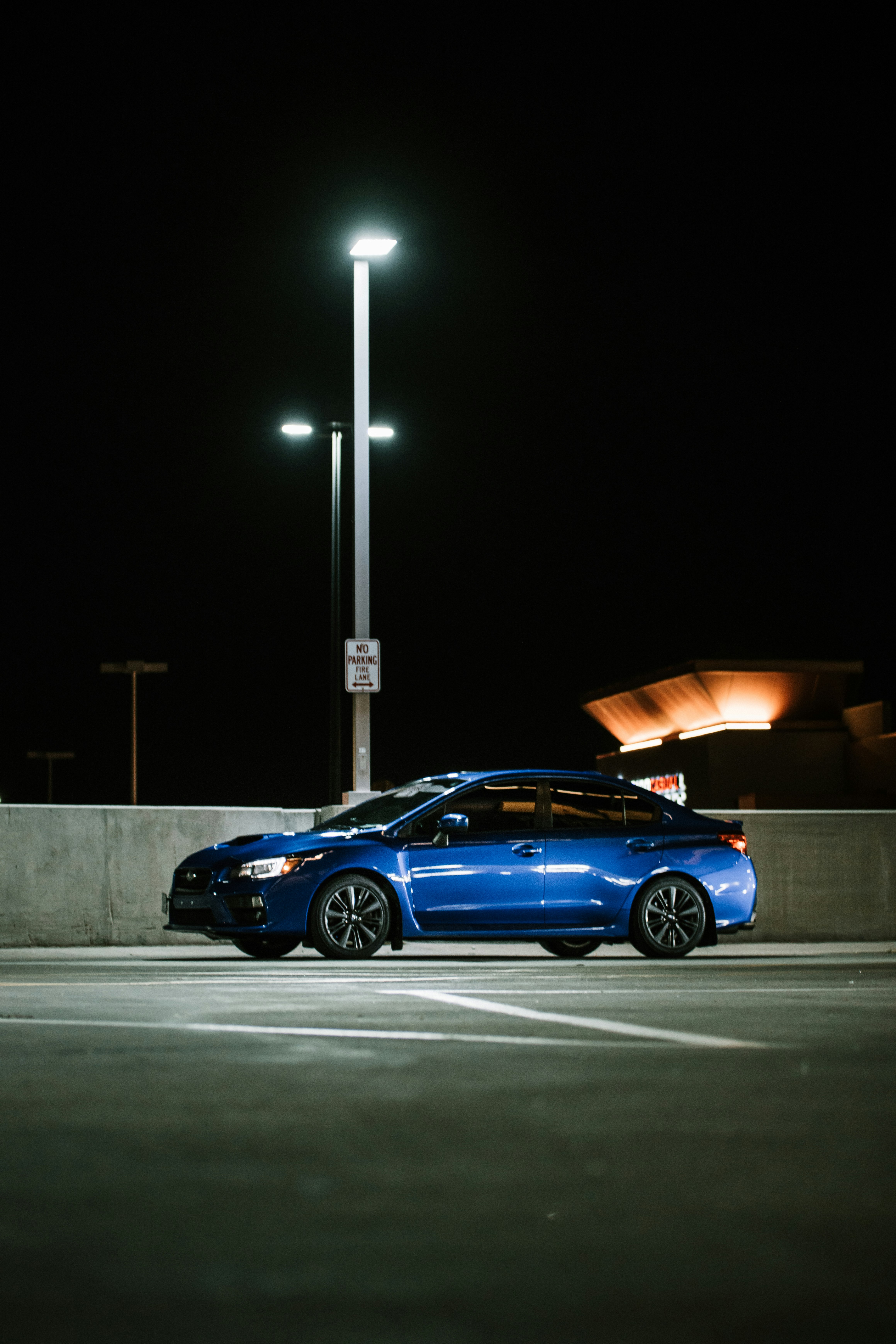 blue sedan on gray asphalt road during night time
