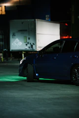 A sleek dark blue utility trailer parked in an urban industrial setting.