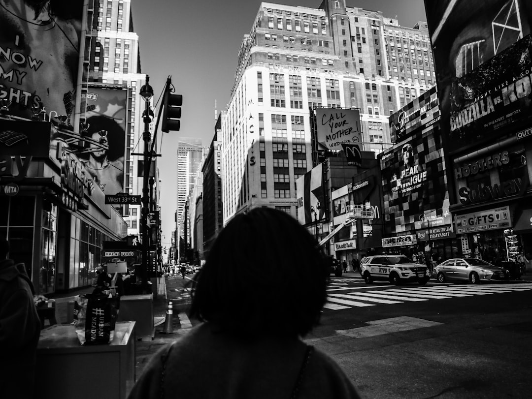grayscale photo of woman walking on street