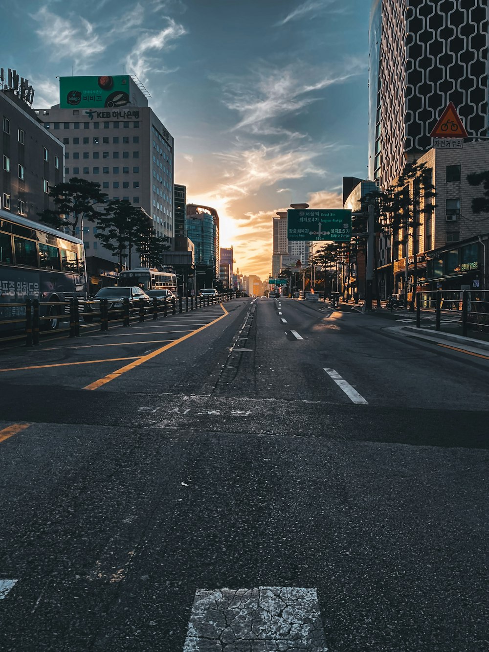 gray asphalt road between high rise buildings during daytime