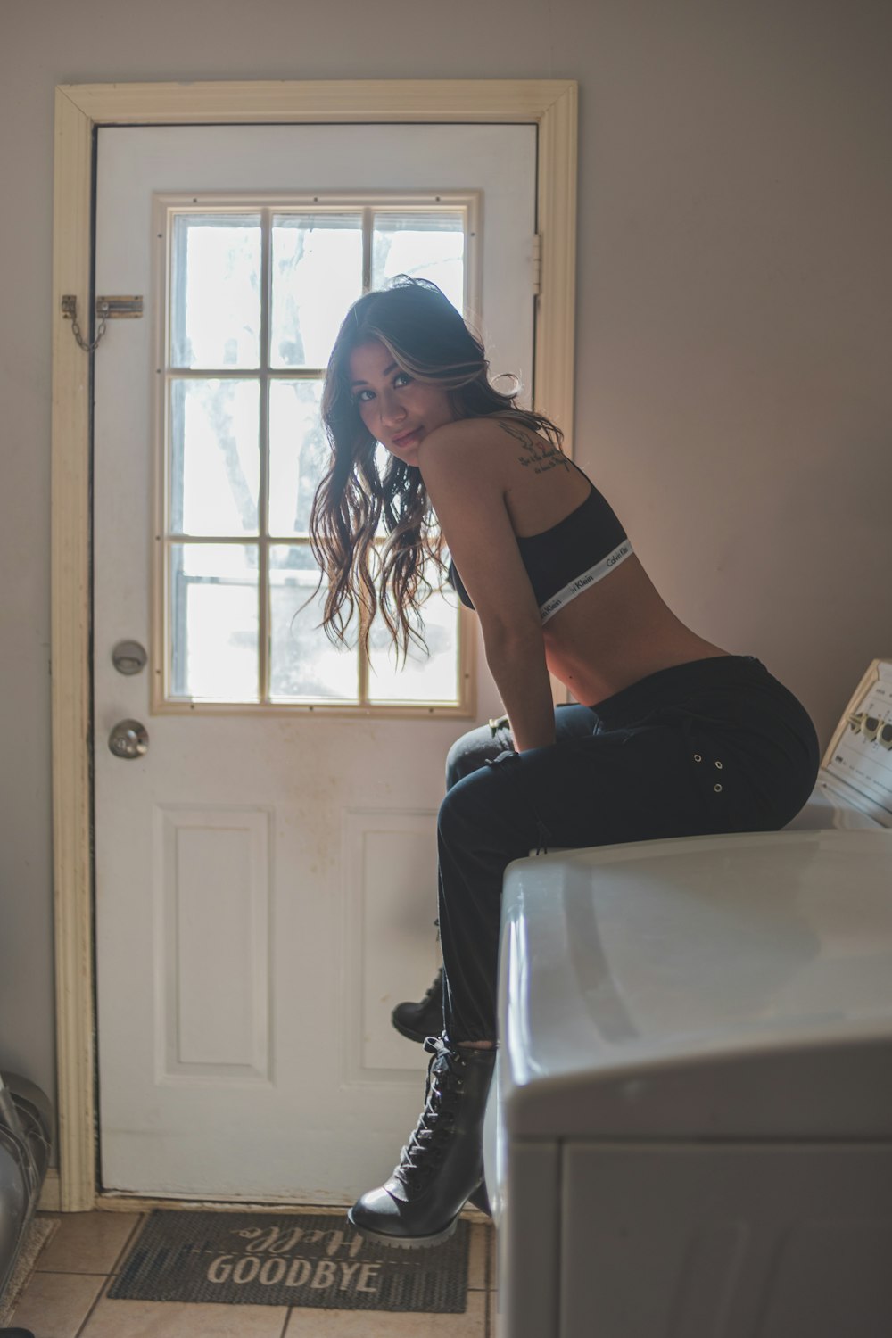 woman in black sports bra and black pants sitting on white table