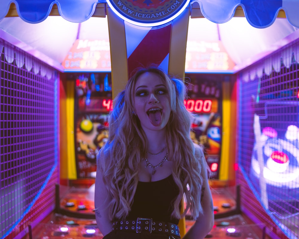 a woman standing in front of a pinball machine