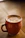 A softly lit photo of a handmade mug resting on a linen cloth beside a steaming cup of coffee.