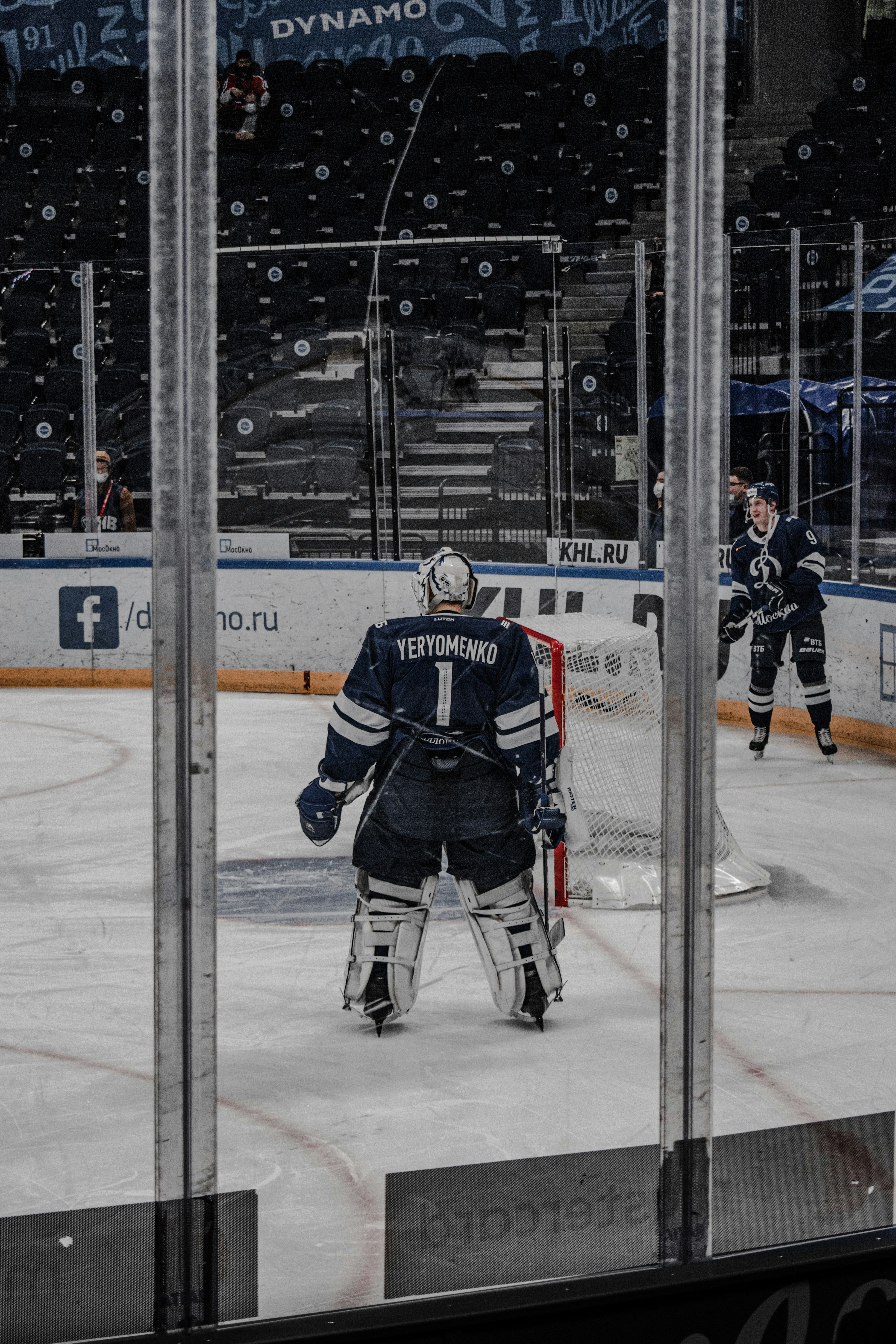 man in black and white ice hockey jersey standing on ice hockey field