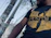 Close-up of a black and red streetwear t-shirt with the Super Elite logo on a city backdrop.
