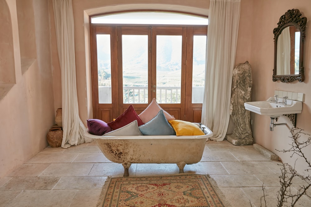 white and brown bathtub near white curtains