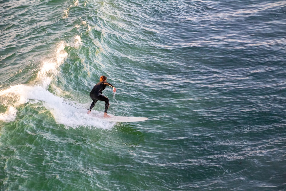 homem surfando nas ondas do mar durante o dia