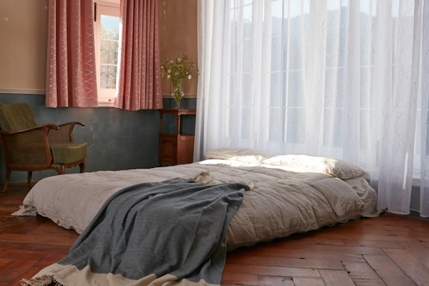 gray textile on white bed
