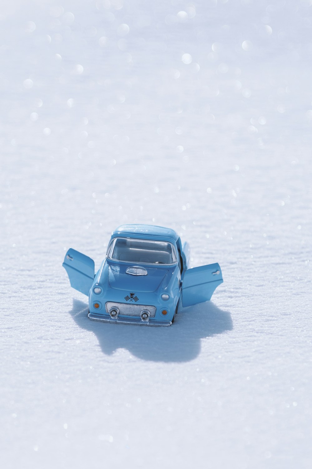 blue volkswagen beetle on snow covered ground during daytime
