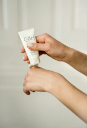 Gentle hands applying moisturizer on healthy skin.