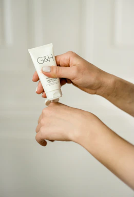 A close-up of hands applying a gentle cream on diverse skin tones.