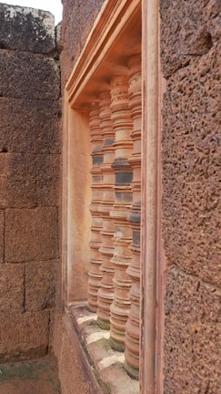 Close-up of weathered stone walls adorned with classic Indian motifs and soft ambient lighting.