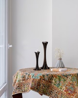 black vase on brown and white floral table cloth