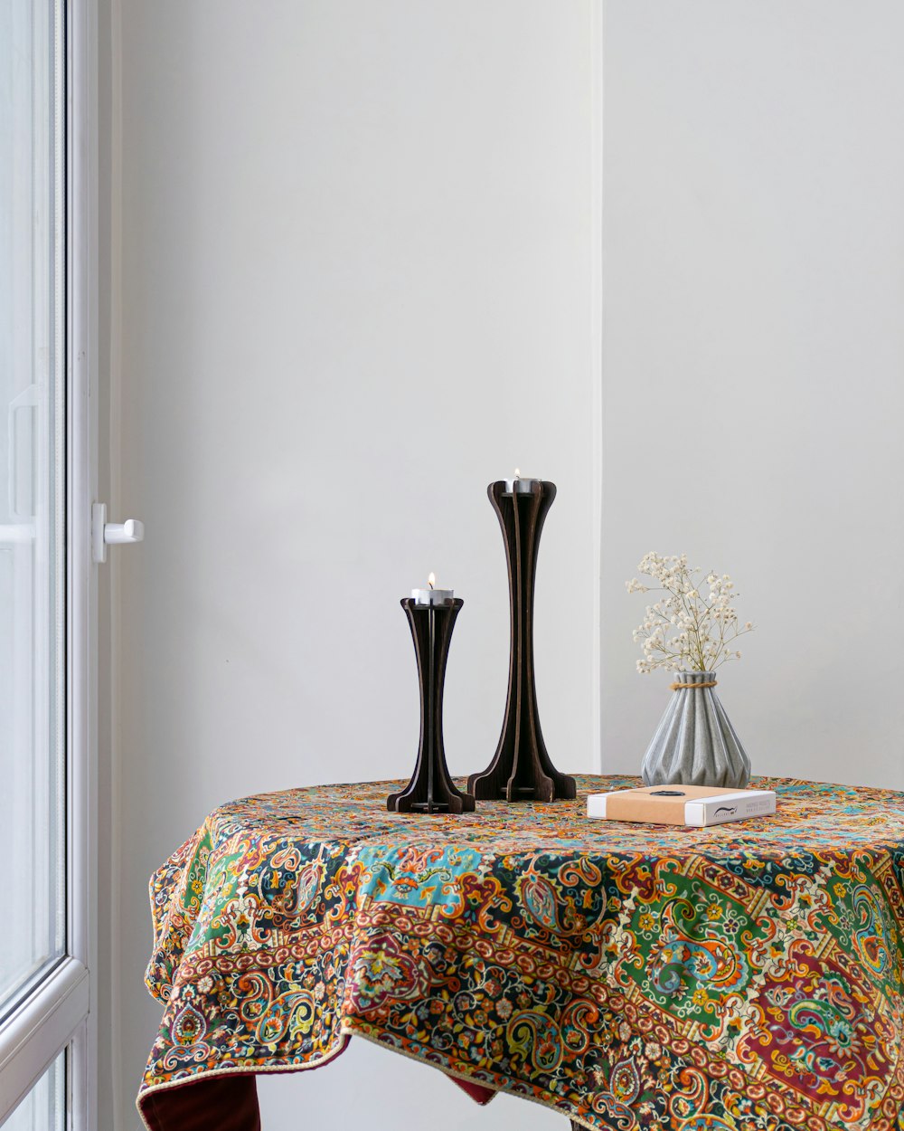 black vase on brown and white floral table cloth