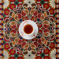 A royal-inspired tea ceremony scene with intricate Indian designs in the background.