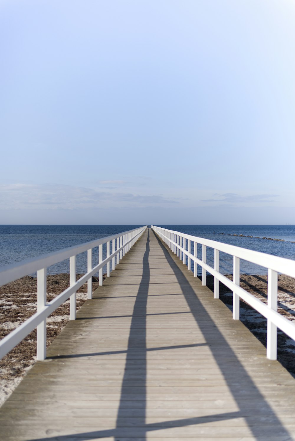 brown wooden dock on blue sea under blue sky during daytime