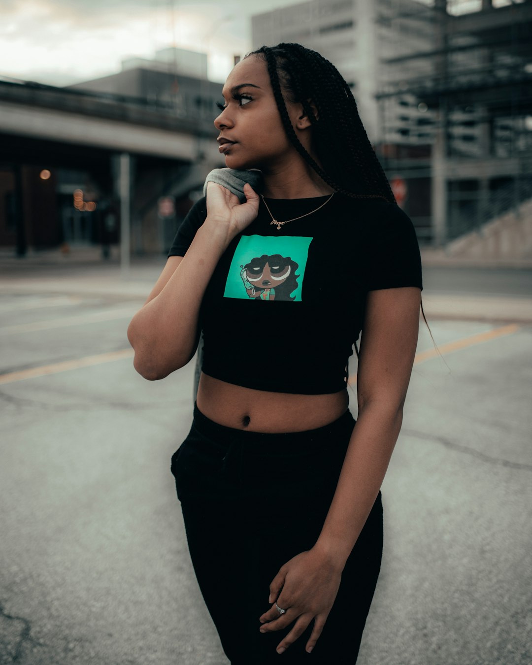 woman in black crop top and black skirt standing on sidewalk during daytime