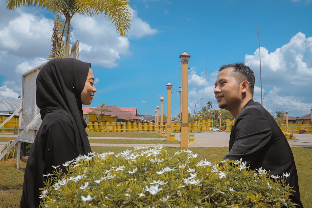 man in black shirt standing near white flower during daytime