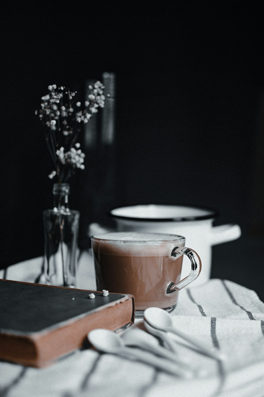 brown ceramic mug on white textile