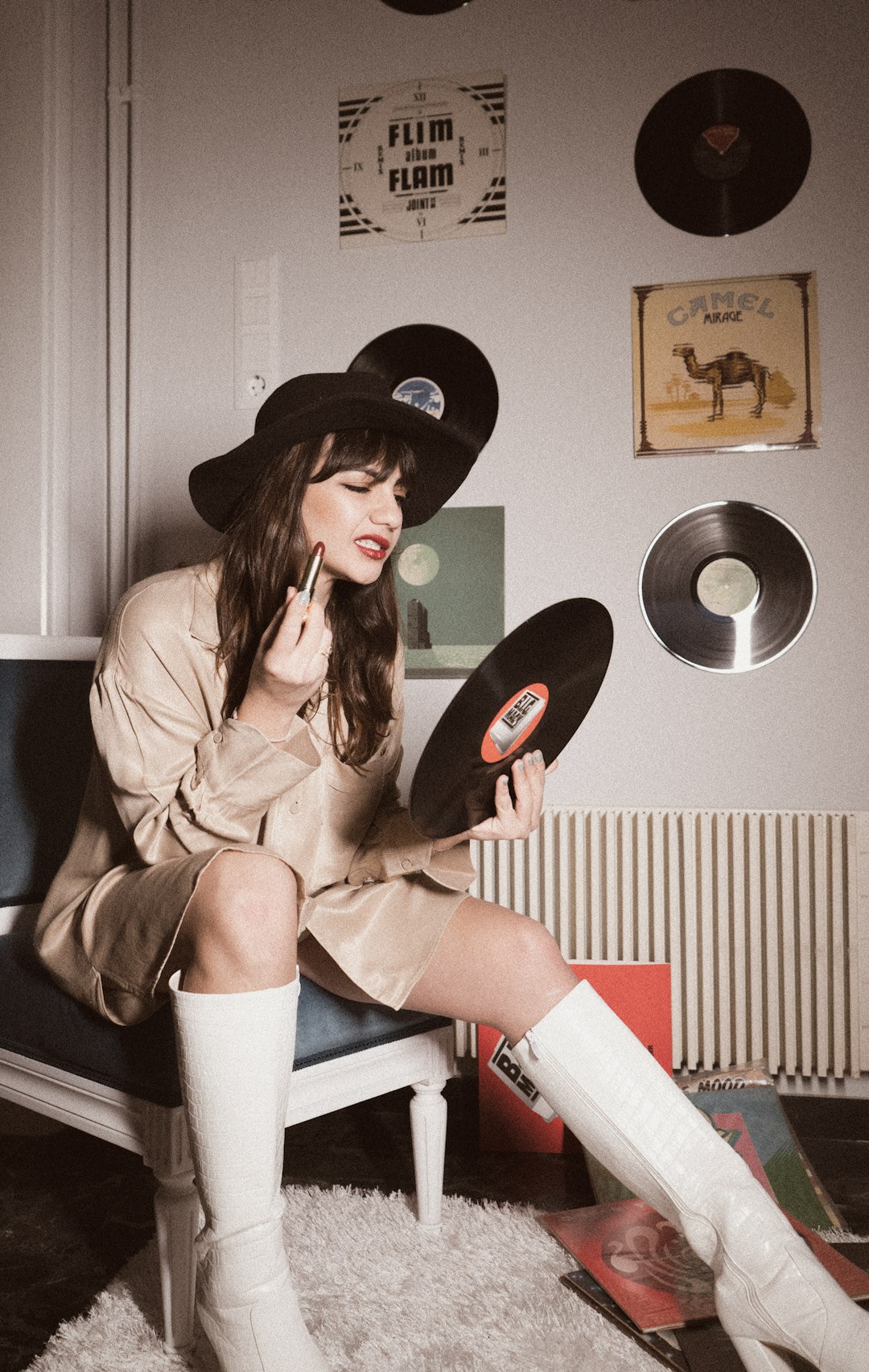 woman in brown coat and black cowboy hat sitting on white chair