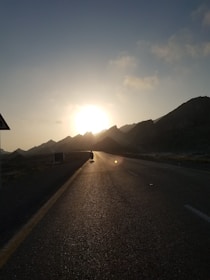 A motorcycle cruising down a scenic highway at sunset.
