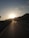A motorcyclist riding through a scenic mountain road at sunset.